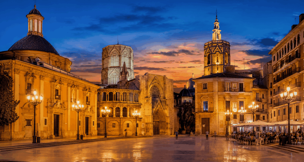 Centro histórico de Valencia al anochecer con la Catedral y edificios monumentales iluminados